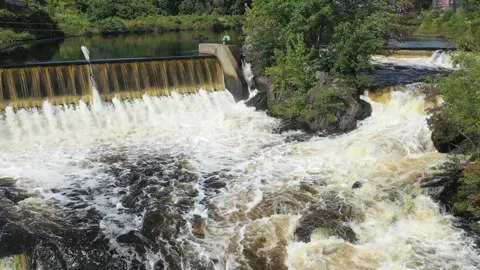 Fly over a raging river near an over-flow dam on a sunny day - aerial orbit Stock Footage 161264188