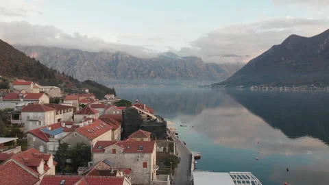 Fly over the red rooftops of Perast towards the majestic mountains Video stock 166496676