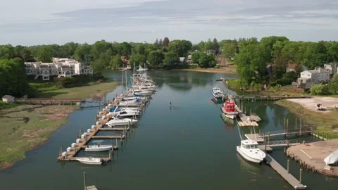 Fly over a river facing a marina and a paddle boarder on a hazy day -aerial shot Stock Footage 161032143