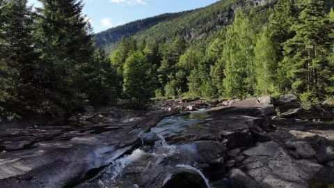 Fly over a river with waterfall between trees in Norway Stock Footage 248360665