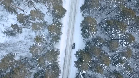 Fly over the road up in the forest winter and rotate Stock Footage 88324079