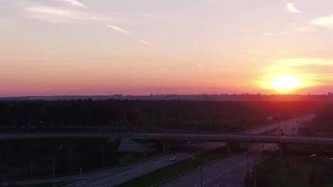 Fly over road junction with moving cars at sunset Stock Footage 76650230