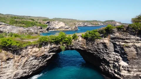 Fly over rock arch over ocean in Broken Beach Stock Footage 159330811