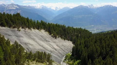 Fly over rocks and cliffs in mountains surrounded by trees, aerial shot Stock Footage 128703244