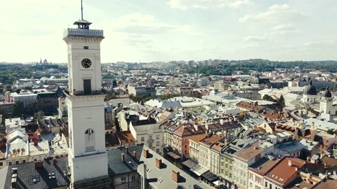 Fly over rooftops, streets and the clock tower at Market Square. Lviv, Ukraine Stock Footage 139200537