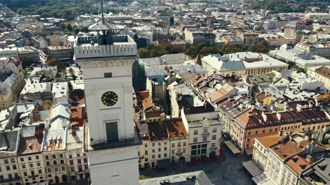 Fly over rooftops, streets and the clock tower at Market Square. Lviv, Ukraine Stock Footage 140986931