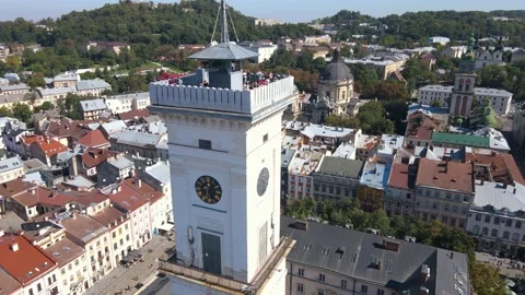 Fly over rooftops, streets and the clock tower at Market Square. Lviv, Ukraine Stock Footage 161121750