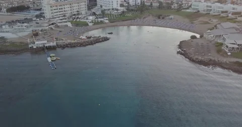 Fly over the sea with the camera rising to the coastline of hotels and beache Stock Footage 145193715