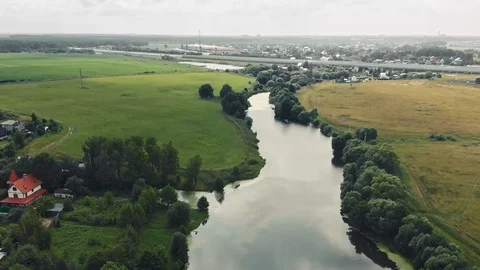 Fly over a small river and green fields Stock Footage
