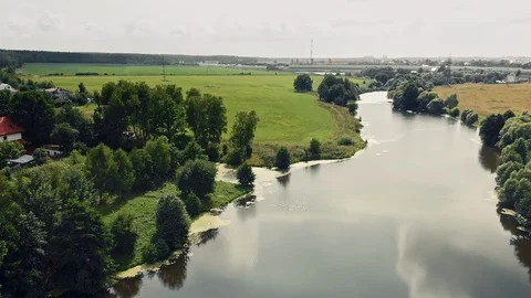 Fly over a small river towards green fields Stock Footage 109608124