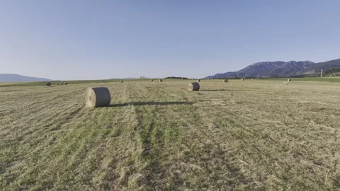 Fly over straw bales. Mountains in the background. Stock Footage 281008433
