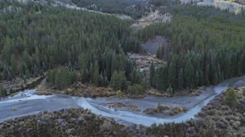 Fly over stream toward valley then turn and follow stream under overcast skies Stock Footage 104154011