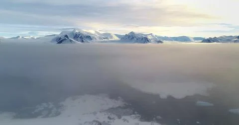 Fly over sunset clouds, mountain peak above Stock Photos