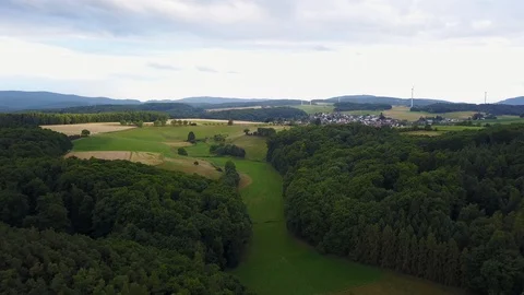Fly over timelapse of green fields with trees and windmills in europe Stock Footage 128738423
