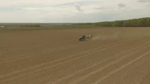 Fly over the tractor on a spring field Close shot Stock Footage 69125682