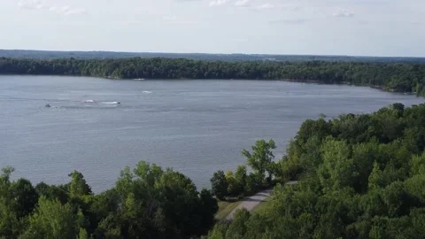 Fly over trees towards boats on lake Stock Footage 158865264
