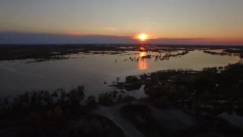 Fly over water overflowed banks of flood river spring sunset 4k aerial top view Stock Footage
