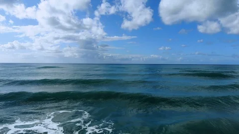 Fly over waves motion,aerial view on deep blue sea water,ocean horizon,cloud sky 스톡 동영상 120087024