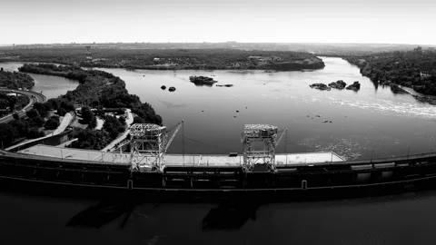 Fly over the weir and power lines of water-power plant. Aerial establishing shot Stock Footage 219894861