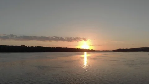 Fly over a wide stream of water, river, at night when the sun sets over the Stock Footage 128724494