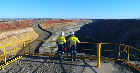 Fly over workers looking over mining pit Stock Footage 113602553
