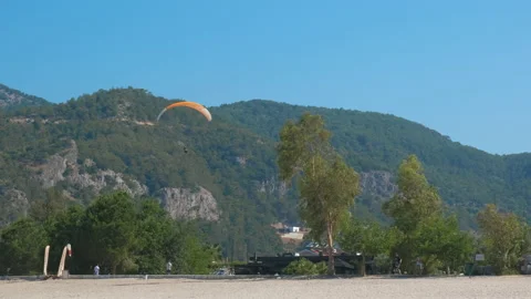 Fly on parachute with ropes on shore. 스톡 동영상 237555593