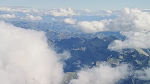 Fly past clouds to see mountains into distance Stock Footage 155525762