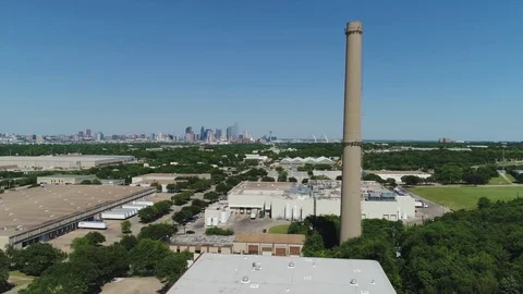 Fly past smoke stack over industrial area with zoom in to high tech city center Stock Footage 75334859