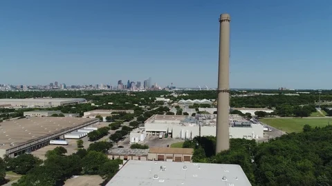 Fly past smoke stack over industrial area to high tech city center Stock Footage 75334883