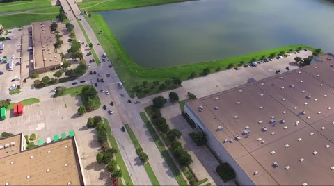 Fly Slow And Low Over Road And Rural Business Complex And Pond Stock Footage 65797496