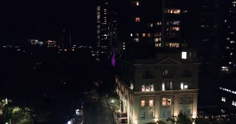 Fly to small old building in modern city night aerial footage Stock Footage 99158790