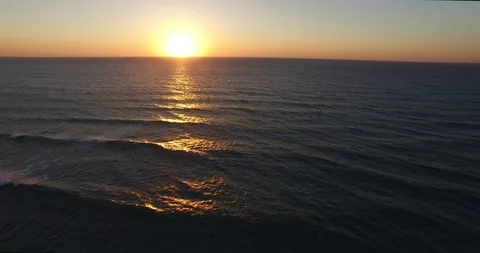 Fly to Sunset above sea water windsurfers over water low level sunlight sunset Stock Footage 89920812