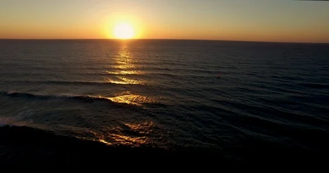 Fly to Sunset above sea water windsurfers over water low level sunlight sunset Stock Footage 89920824