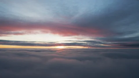Fly through cloud tips that are being illuminated with a pink hue at Stock Footage 102224552