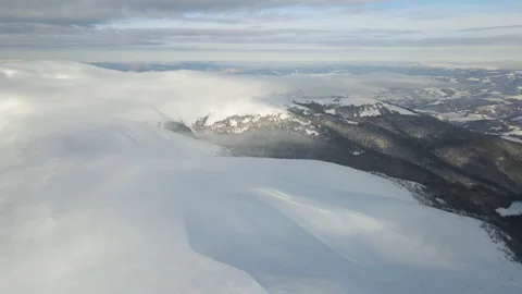 Fly through the clouds over the mountain peaks. Amazing aerial flight over misty Stock Footage 172406023
