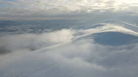 Fly through the clouds over the mountain peaks. Amazing aerial flight over misty Stock Footage 173048559