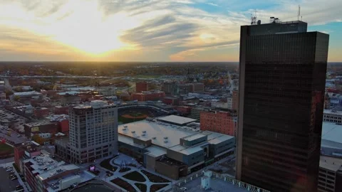 Fly-through of downtown Toledo, Ohio toward baseball stadium, sunset Stock Footage 257129376