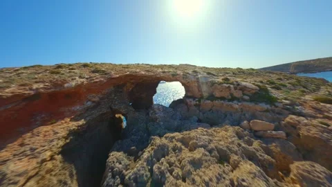 Fly through the natural rock window on Comino island, Blue lagoon. Malta island Stock Footage 314669355