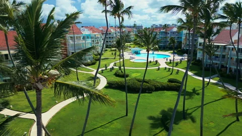 Fly-through palm trees towards luxury tropical residential estate, swimming pool Stock Footage 309471595