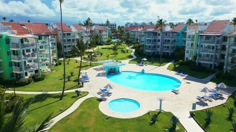 Fly-through palm trees towards luxury tropical residential estate, swimming pool Stock Footage 309941016