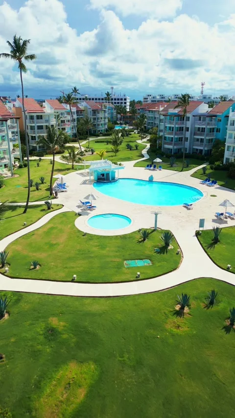 Fly-through palm trees towards luxury tropical residential estate, swimming pool 스톡 동영상 309941197