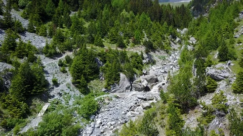 Fly-through river in mountain towards waterfall with green trees Stock Footage 128698413