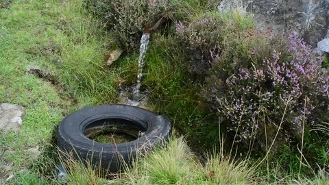 Fly tipping by beaitiful stream north yorkshire moors united kingdom Stock Footage 148828861