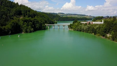 Fly toward bridge on beautiful huge turquoise lake Stock Footage 128732386