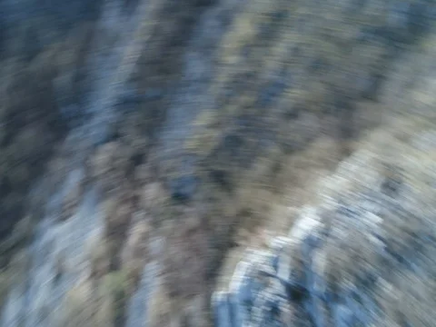 Fly towards rocks on a mountain in spring with yellow grass and white rocks Stockbeeldmateriaal 75462721