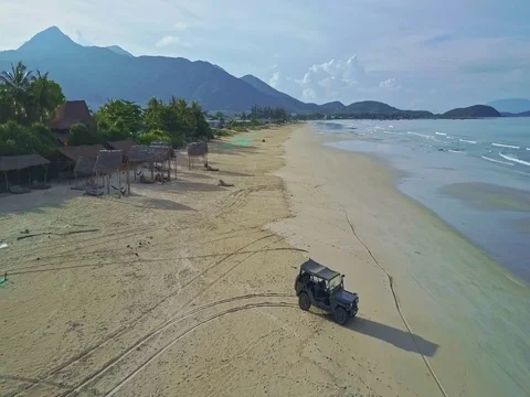 Flycam Removes from Military Jeep Standing on Beach to Sea Stock Footage