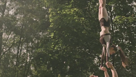 Flyer Girl Performing Handstand Split in Air with Base Athlete Stock Footage 249268159