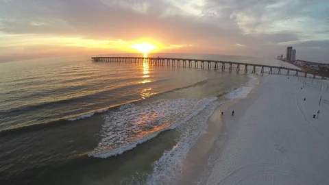 Flying 360 degrees around a pier, beach and ocean waves at sunset time. Stock Footage 90562833
