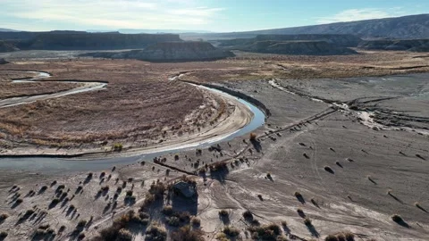 Flying above abandoned cattle ranch next to a river-bend in the desert Stock Footage 165567189