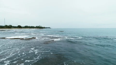 Flying above the beach, with interesting pattern of waves and coral Stock Footage 100957106